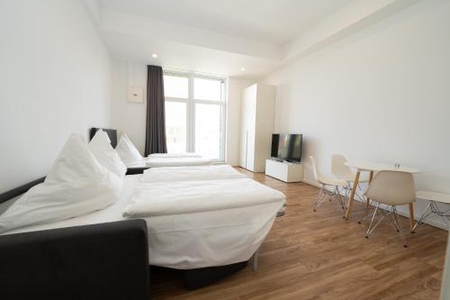 a bedroom with two beds and a table and chairs at Das Loft Apartments in Aachen