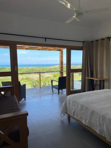 a bedroom with a bed and a view of the ocean at Altos de la Caobita in Barreras