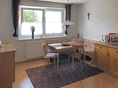 a kitchen with a table and a cross on the wall at Gartenwohnung Gößweinstein in Gößweinstein