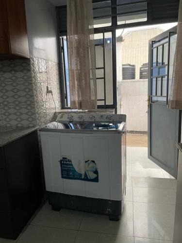 a kitchen with a stove top oven in a room at KGL RITHA Apartment in Kigali