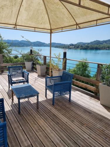a deck with two blue benches and a view of the water at Aquabella in Aiguebelette-le-Lac