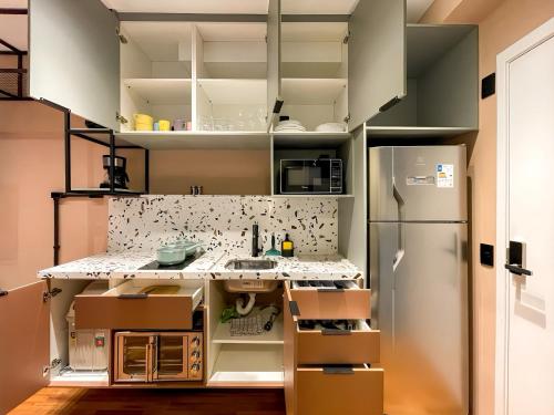 a small kitchen with white cabinets and a refrigerator at Condomínio com piscina ao lado do Parque Buenos Aires in Sao Paulo
