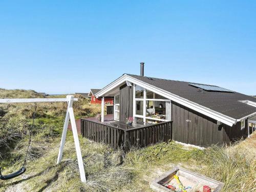 a house with a solar roof on top of a field at 8 person holiday home in Hjørring-By Traum in Kærsgård Strand