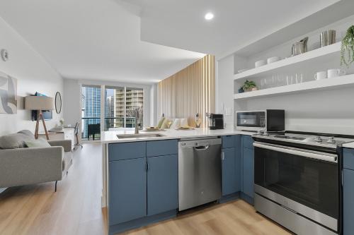 a kitchen with blue cabinets and a living room at Private Oasis at Arya in Miami