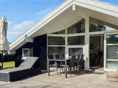 a house with a table and chairs on a patio at 8 person holiday home in Sydals-By Traum in Skovmose