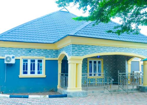 una pequeña casa azul con techo en Revolution Apartment Lemode Kobape abk, en Abeokuta