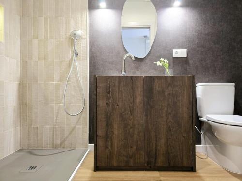 a bathroom with a toilet and a mirror at Lhome Macarena in Seville