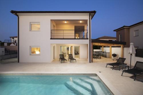 a house with a swimming pool in front of a house at Villa D&J in Vodnjan