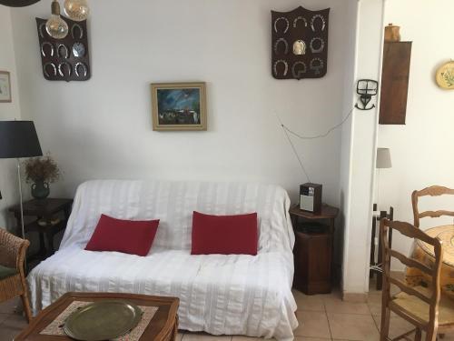 salon z białą kanapą i czerwonymi poduszkami w obiekcie Petite marie w Saintes-Maries-de-la-Mer
