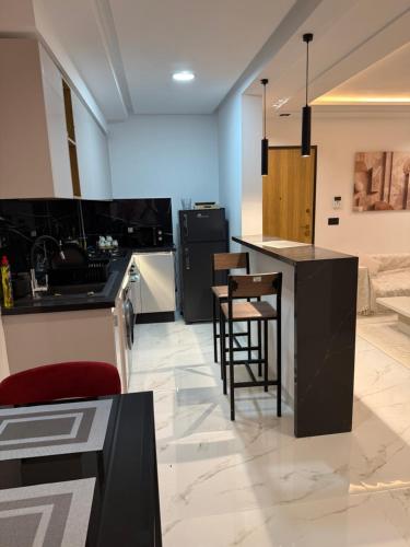 appartement A33 في Burj at Turkī: مطبخ مزود بمنضدة وكراسي في غرفة