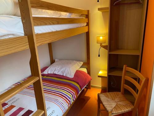 a room with two bunk beds and a chair at Auberge de Perchades in Bilhères en Ossau
