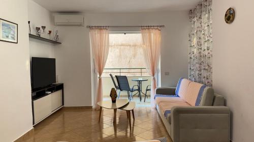 a living room with a couch and a table at Klesta Apartment - Design, Komfort & Top-Lage mit Meerblick in Sarandë