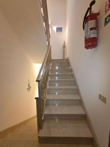 a staircase with a fire hydrant hanging on the wall at Casa vacanza Nicla in Rosolini