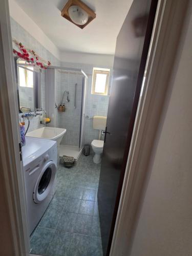 a bathroom with a toilet sink and a washing machine at Casa vacanza Nicla in Rosolini