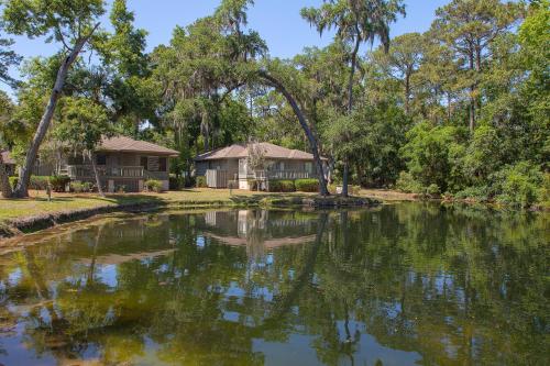 a house next to a lake with trees at Carolina Club by Spinnaker Resorts in Hilton Head Island