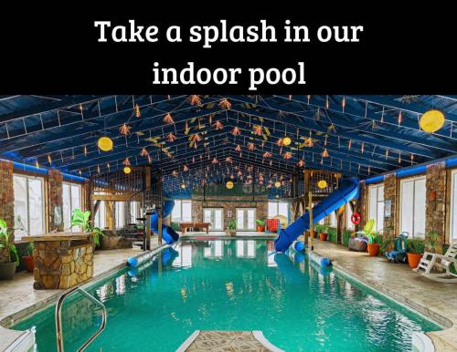 a swimming pool with a slide in an indoor pool at Mountain High Cabin with hot tub fire pit & indoor pool in Bryant