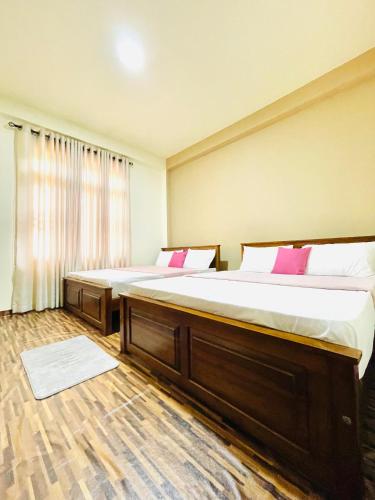 a bedroom with two beds and a large window at Yemi Bungalow Ella in Ella