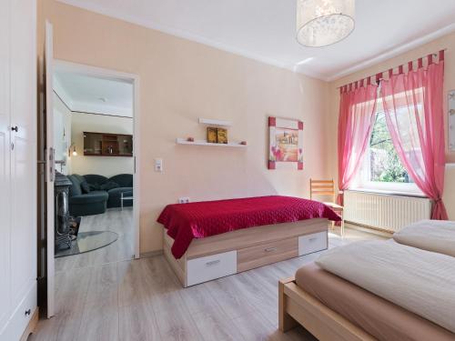 a bedroom with a bed with a red blanket at Cozy Escape Near the Baltic in Gingst