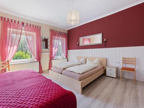 a bedroom with a bed and a red wall at Cozy Escape Near the Baltic in Gingst