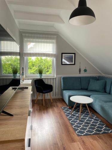 a living room with a blue couch and a table at Dormare in Grzybowo