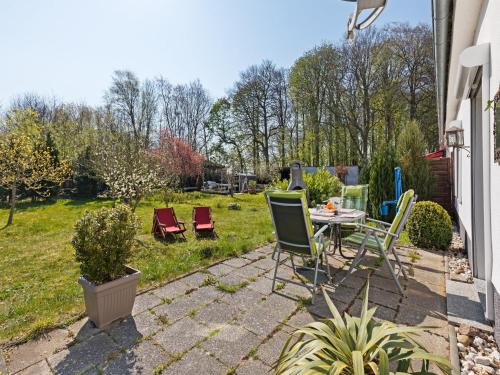 a patio with a table and chairs in a yard at Cozy Escape Near the Baltic in Gingst