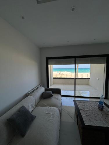 a living room with a couch and a view of the beach at Luxury apartments in Hiboun