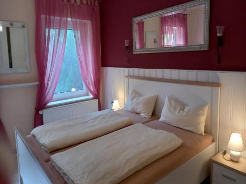 a bedroom with a bed with two pillows and a mirror at Cozy Escape Near the Baltic in Gingst