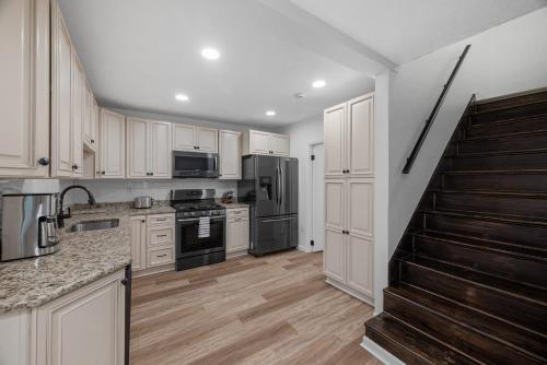 a kitchen with white cabinets and stainless steel appliances at Modern & Spacious Four Bedroom Apartment in Gibsonia, Pittsburgh, Unit 1 in Bakerstown
