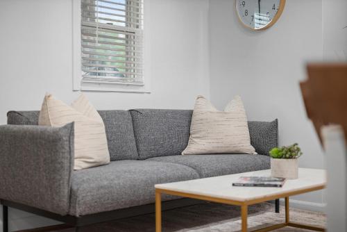 a living room with a gray couch and a coffee table at Modern & Spacious Four Bedroom Apartment in Gibsonia, Pittsburgh, Unit 1 in Bakerstown