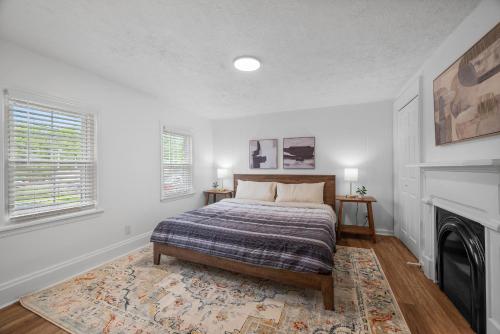 a white bedroom with a bed and a fireplace at Modern & Spacious Four Bedroom Apartment in Gibsonia, Pittsburgh, Unit 1 in Bakerstown