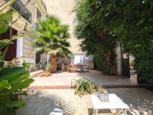a patio with a table and chairs and trees at Portrait Boutique Guesthouse in Valencia