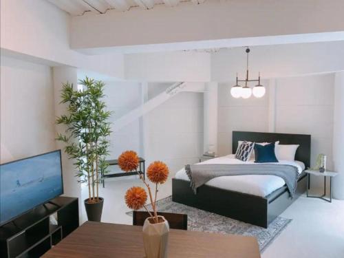 a bedroom with a bed and a tv and a table at Fleg Higashi Azabu in Tokyo