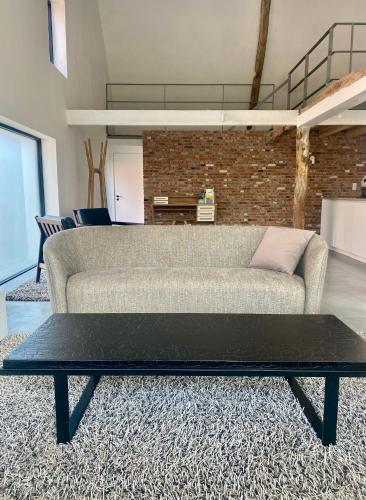 a living room with a couch and a coffee table at Hoeve DeKleinheide 1 in Dessel