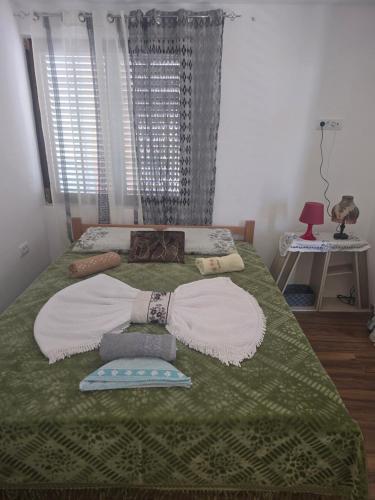 a large bed with blankets and pillows on it at Yellow hill Batinac in Ćuprija