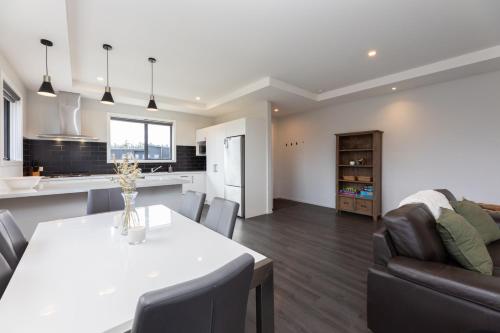 a kitchen and living room with a table and a couch at Ski, Bike, Eat, Swim, Relax. in Methven