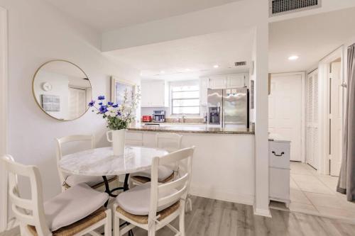 a kitchen and dining room with a table and chairs at Park Shore Resort Deluxe Condo, water views 232 in Naples