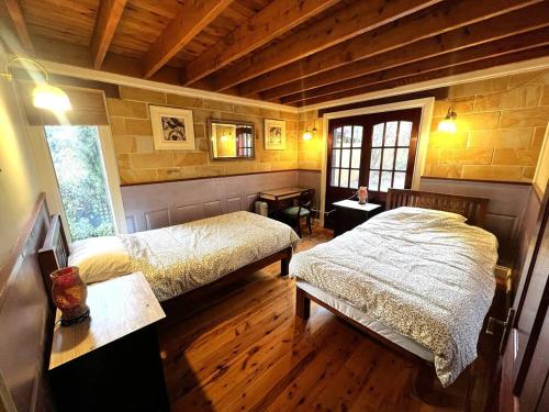 肯图巴Cottage on Cliff sunset, relaxing and warm的一间铺有木地板的客房内配有两张床的卧室