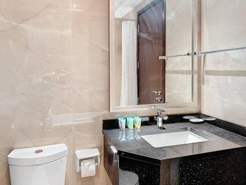 a bathroom with a white toilet and a sink at Stunning studio in Downtown Dubai in Dubai