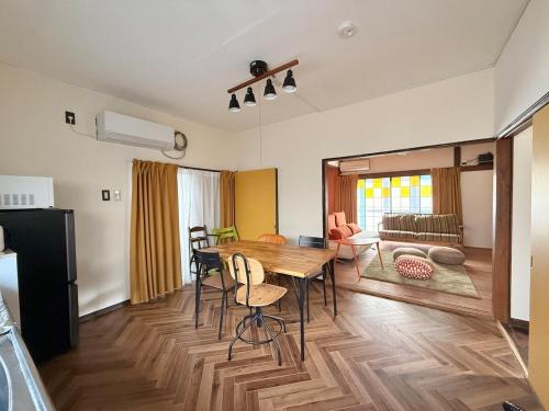 a kitchen and living room with a wooden table and chairs at Vintage House Cortile of HIMAWARI in Matsudo