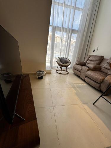 a living room with a couch and a large window at Cabin in zahra elalamein in El Alamein