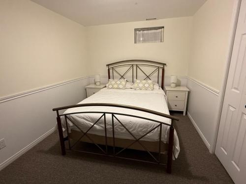 a bedroom with a bed with a metal frame at Luxurious Lakefront Cottage, Sleeps 12 in Bewdley