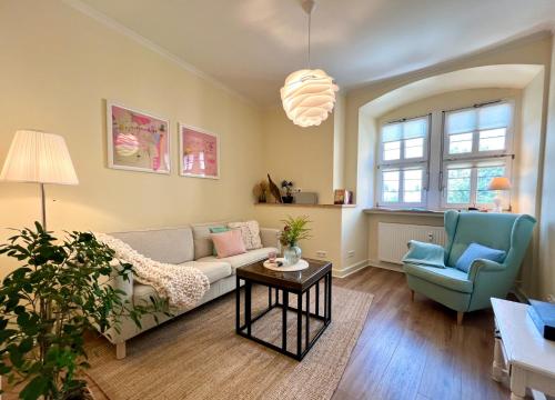 a living room with a couch and a chair at GRÄFIN MARTHA MARIA - Design-Apartment in der historischen Hinterburg Schlitz - mit Aufzug, Parkplatz & Garten - nahe Fulda und Bad Hersfeld in Schlitz