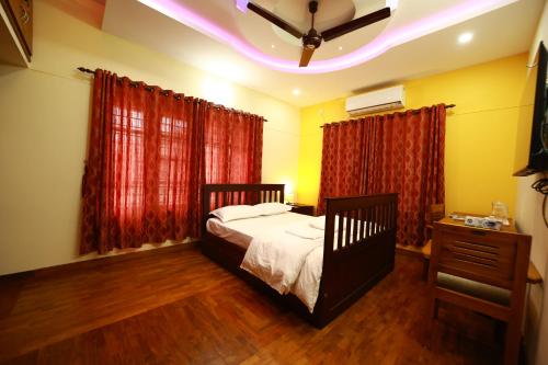 a bedroom with a bed and a ceiling fan at Spice Haven Homestay in Trivandrum