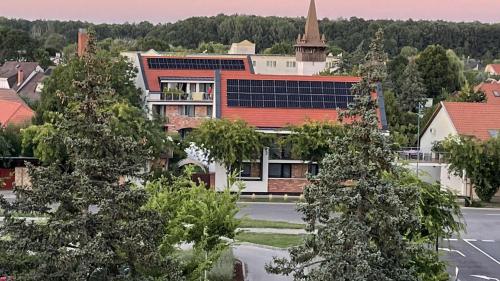 a view of a school building with a church at Castellum Apartmanház in Gyula