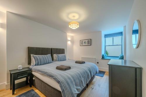 Un dormitorio con una cama grande y una ventana. en Spacious Modern 2-bed Parking & Wi-Fi & 65"OLED, en Bristol