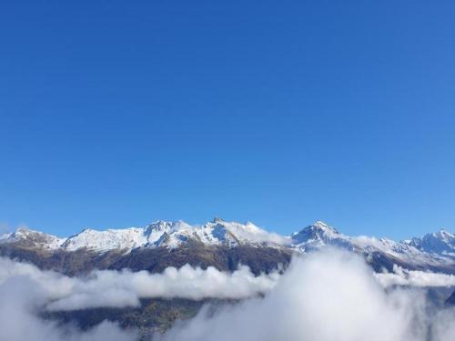 a view of snow covered mountains from above the clouds at Chalet in Rhone Valley near Ski Lift in Les Collons