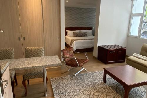 a room with a bedroom with a bed and a table at Hotel Portón de la Cabrera in Bogotá