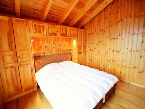 a bedroom with a bed in a wooden room at Chalet in Rhone Valley near Ski Lift in Les Collons