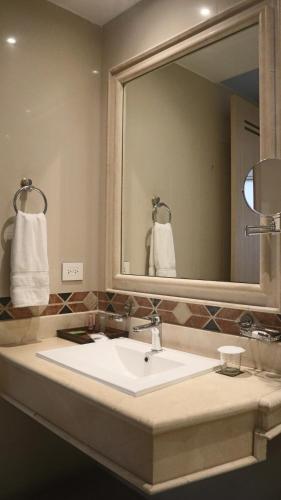 a bathroom with a sink and a large mirror at Hotel Portón de la Cabrera in Bogotá