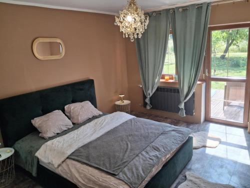 a bedroom with a large bed and a chandelier at Leśny zakątek in Rękusy